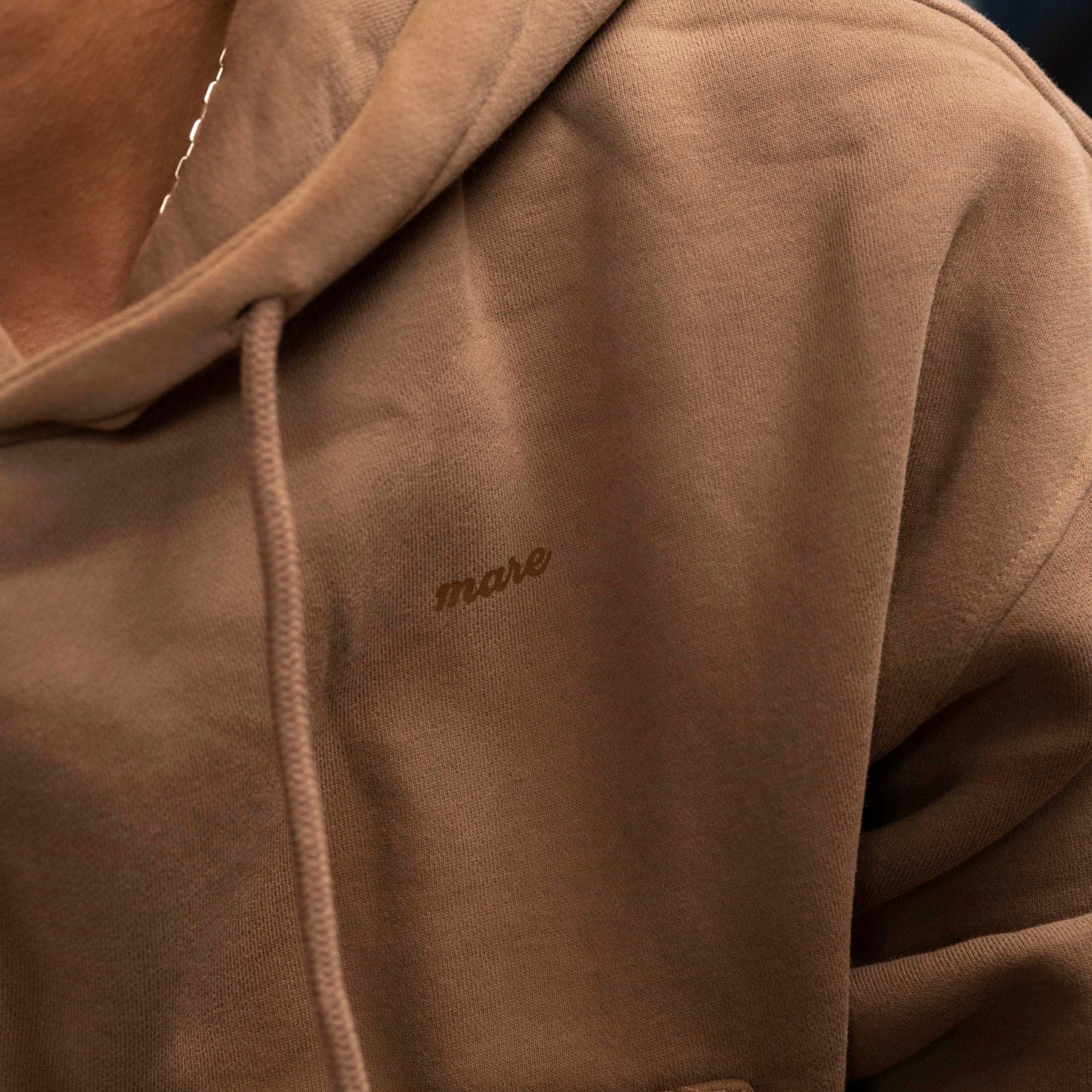 Mare Hoodie in color brown with the Mare logo.