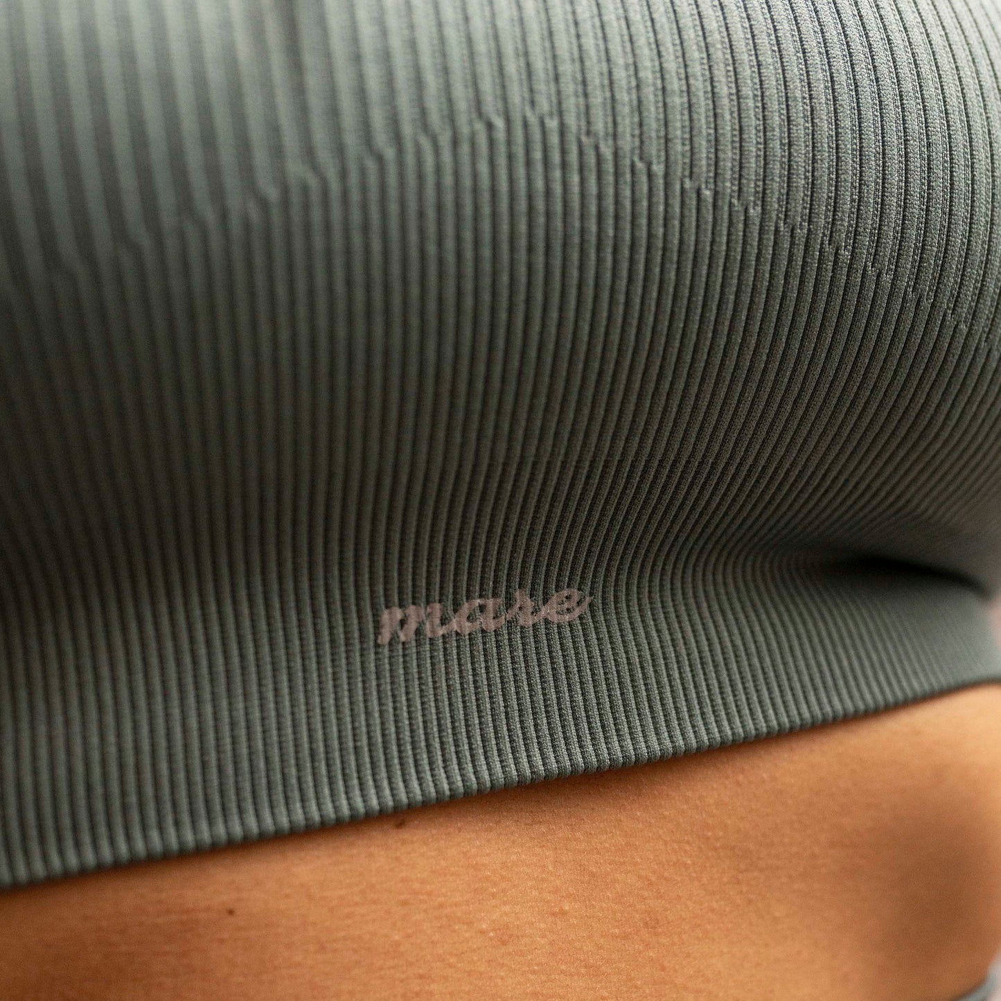 Model close-up of Mare's Seamless Ribbed Yoga Set in artic color with Mare branding.