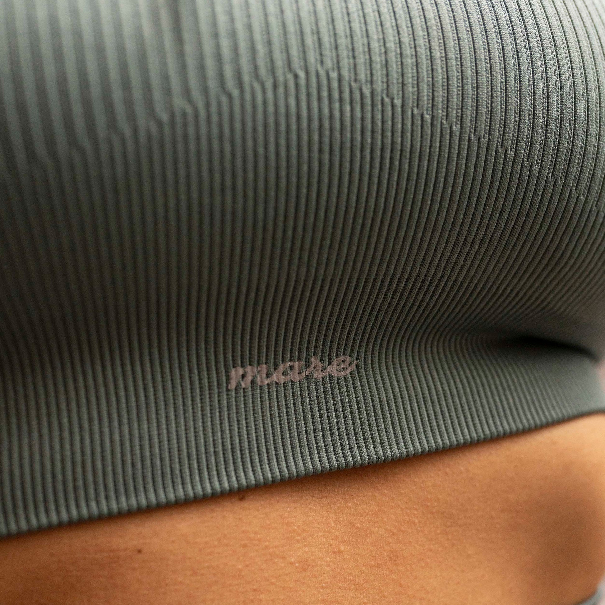 Model close-up of Mare's Seamless Ribbed Yoga Set in artic color with Mare branding.